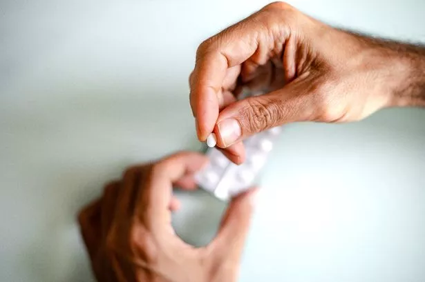 Close up of unrecognizable man taking meds/ supplements / medicine