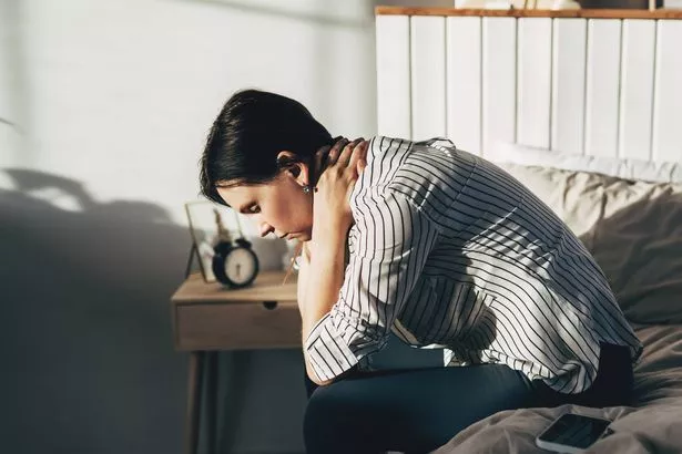 A woman feeling stressed and tired in the bedroom