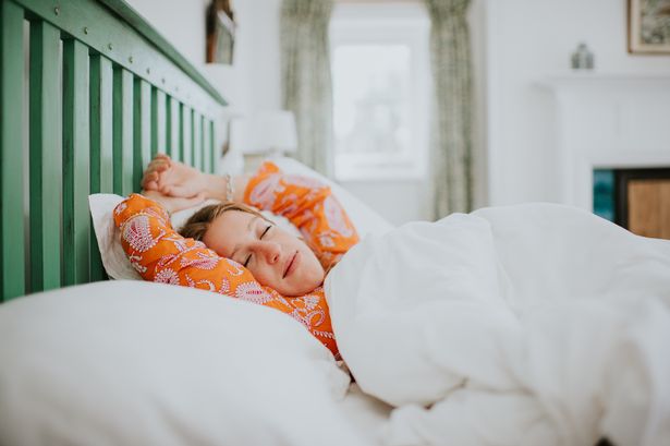 Woman sleeping in bed after using Protein Works' Sleep Deep supplement