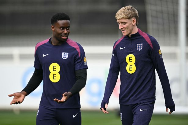 England's midfielder Anthony Gordon (R) and England's defender Marc Guehi attend a training session at St George's Park