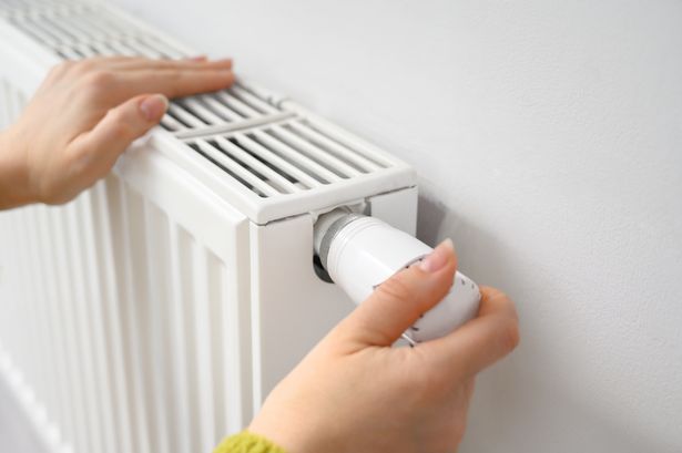 Close-up of hands adjusting home radiator thermostat. Concept of energy efficiency, indoor climate control, smart home technology, winter heating, and utility cost savings.