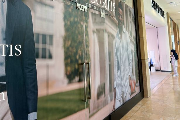 Photo shows opening soon sign outside shop