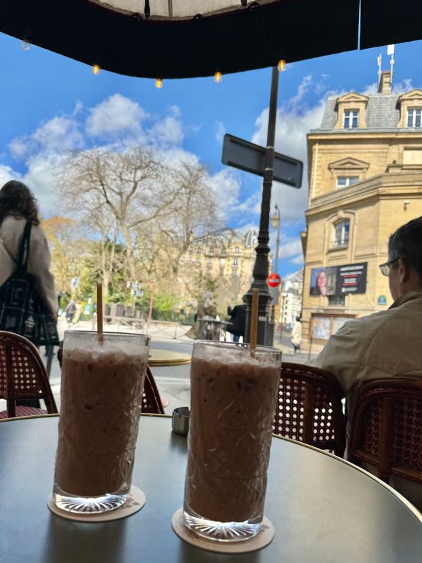 Two drinks at the terrace of a bar, clear skies and buildings