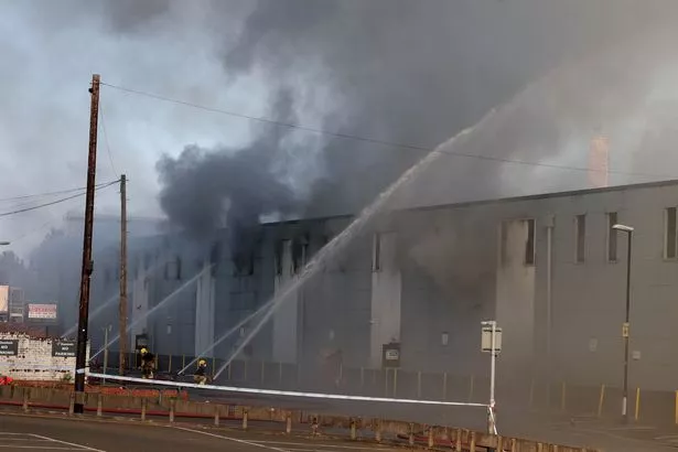 Smoke pours from the building during the fire
