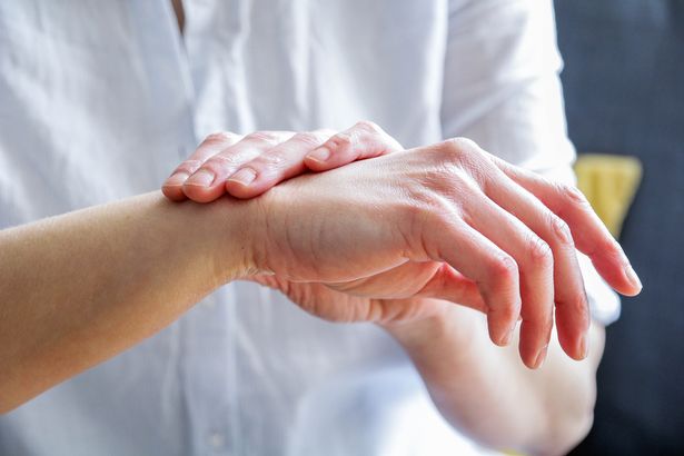 Close up of a woman itching her hand with eczema