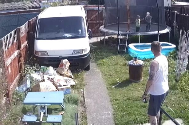 CCTV image issued by North Wales Police of Michael Ives (right) watching two-year-old Ethan Ives (yellow T-shirt) on a trampoline in the back garden of the family home in Garden City, Deeside. 