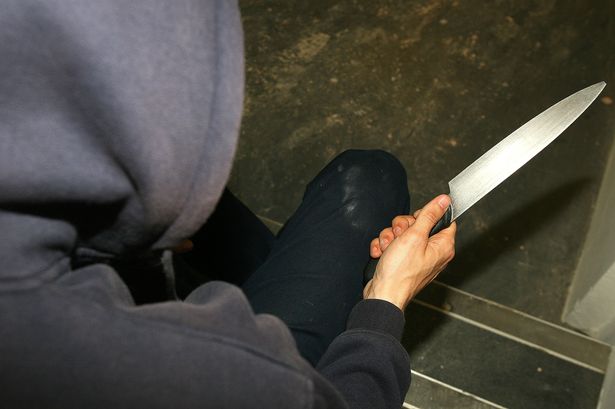 Hooded person with knife
