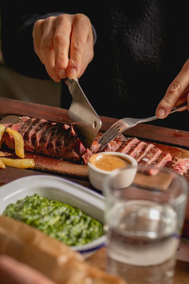 A steak with spinach side dish at Flat Iron, which is opening in Bristol