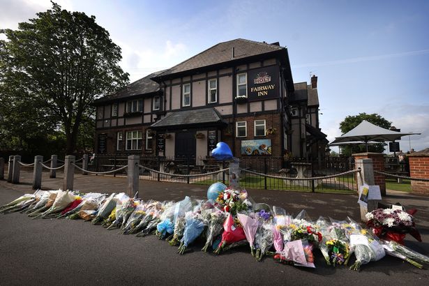 Tributes left outside the Fairway Inn in New Moston