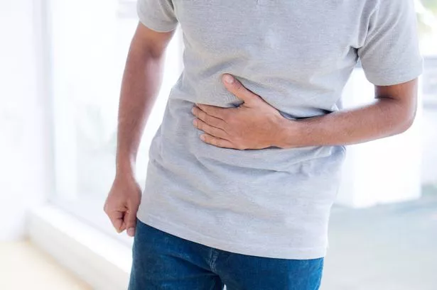 Man touching his stomach in pain.