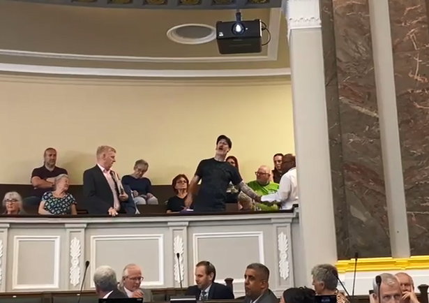 A man in the public gallery is escorted out after interrupting a Birmingham City Council meeting