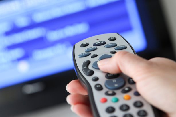 Woman uses remote to watch TV