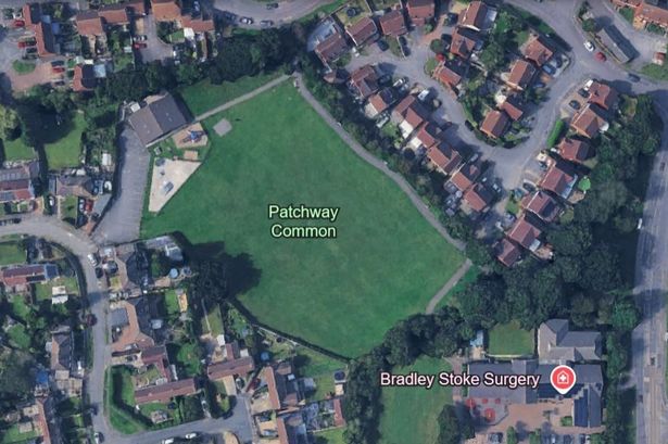 Aerial view of field in middle of housing estate