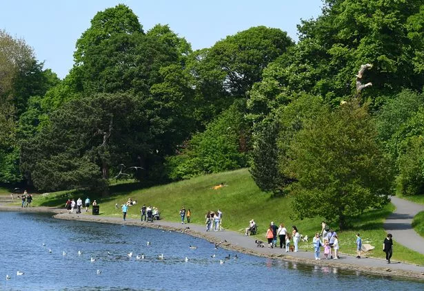 People enjoying a walk around the lake in Sefton Park