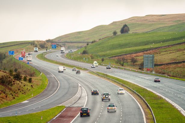 Cars, buses and trucks on the M6 Motorway in England during rainy weather.