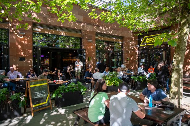 Photo shows people sat on benches on terrace