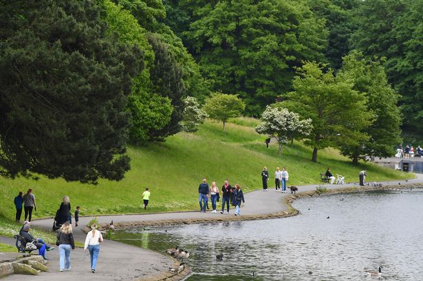 Families enjoying a walk around Sefton Park Lake,