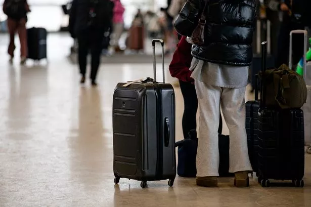 A picture of a passenger holding a suitcase at the airport