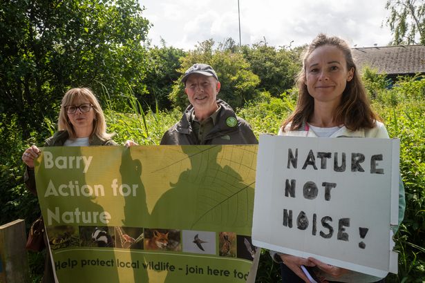 Three people holding up a sign