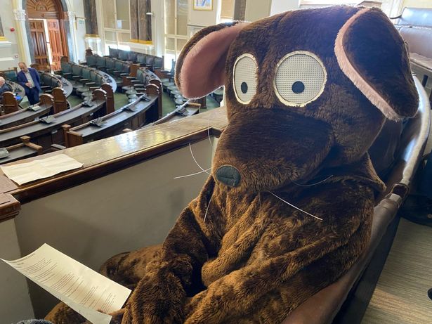A man in a rat costume before a full council meeting at Birmingham City Council House.