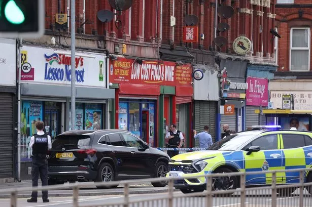 Police working inside the cordon on Stanley Road where a woman was stabbed to death