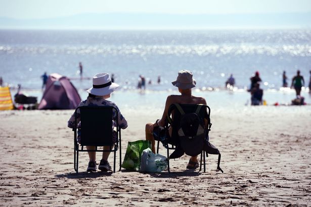 Two people sitting on chains, on beach