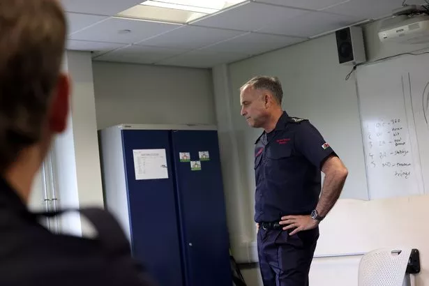 A manin fire service uniform with hands on his hips