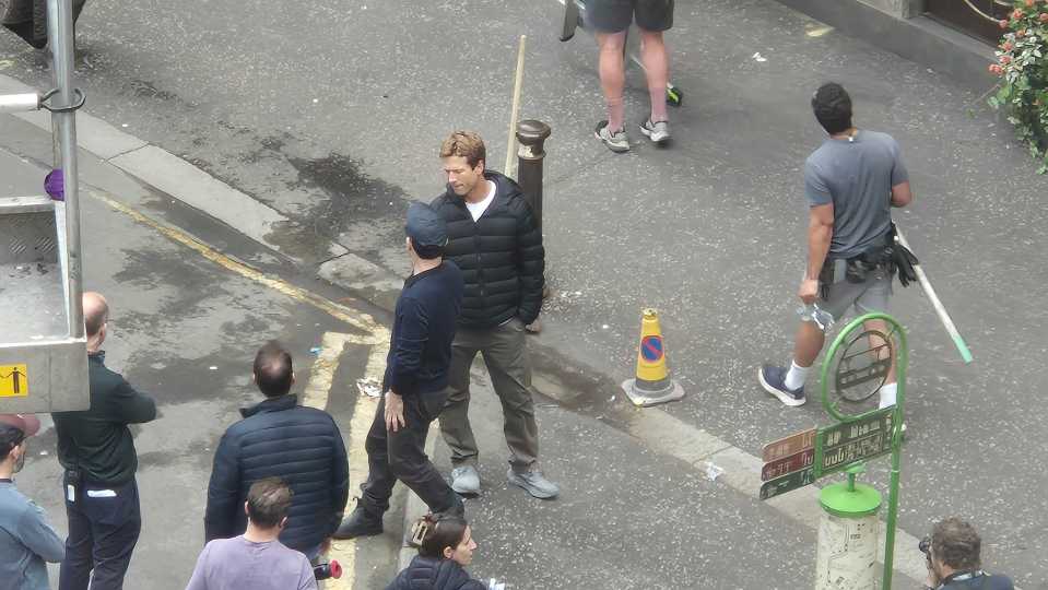 Overhead view of a film set with several people, including one man in a dark jacket.