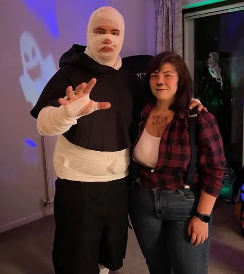 Two people in Halloween costumes; one is a mummy, the other is a lumberjack.