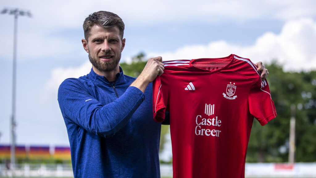 Jason Oswell holds up a Connah's Quay Nomads shirt after joining the JD Cymru Leagues Premier side from Newtown