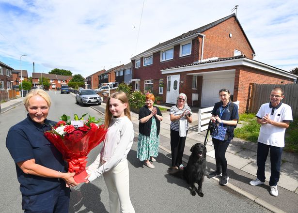 Paula Prescott from the Forshaw Group (far left), receives a bouquet of flowers from Bulwer Street residents, including 13 year old Izzy, applauded by ltr Liz Earnshaw, Lin Crilly, Sarah with guide dog Ronnie, and John Bowden