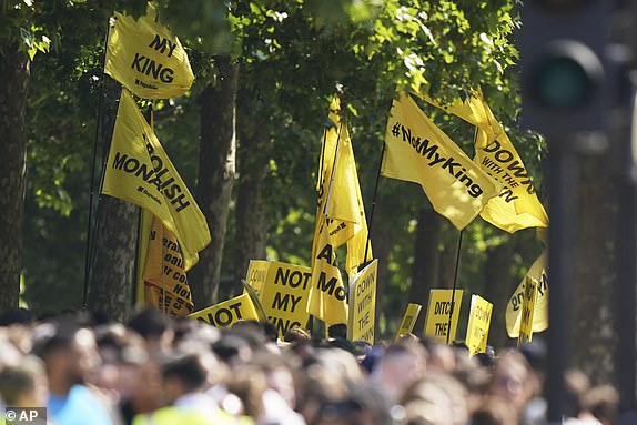 Republican 'Not My King' protesters wave banners and flags in the Mall ahead of the start of the Trooping the Color in London, Saturday, June 14, 2025. (AP Photo/Alberto Pezzali)