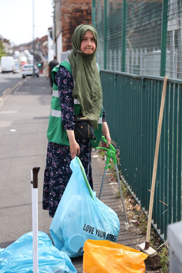 Naima Khan from Friends of Spark Green Park volunteer litter picking group with rubbish on Taunton Road, Balsall Heath, Birmingham.