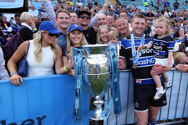 Finn Russell celebrates with the Premiership trophy at full-time along with family