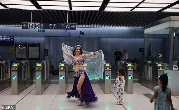 epa12184355 A belly dancer performs as people spend the night in the underground Tel Aviv Light Rail Station, amid the ongoing Iranian ballistic missile threat, in Tel Aviv, Israel, 18 June 2025. Israel and Iran have been exchanging fire since Israel attacked Iran on 13 June 2025 as part of operation 'Rising Lion'.  EPA/ABIR SULTAN