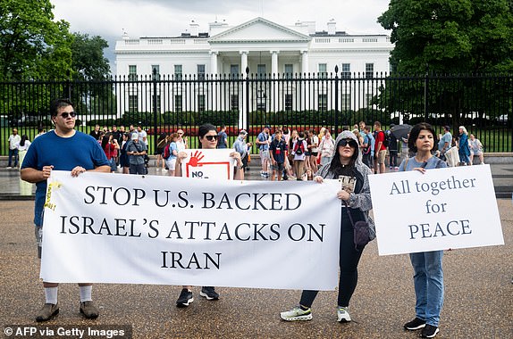 People hold a banner as they protest the Israeli strikes on Iran and any potential US involvement in the conflict during a "No War on Iran" demonstration outside the White House in Washington, DC, on June 18, 2025. US President Donald Trump said on June 18 that he was still deciding whether to join Israel's strikes on Iran, claiming Tehran now wants talks at the White House but may have waited too long. (Photo by SAUL LOEB / AFP) (Photo by SAUL LOEB/AFP via Getty Images)