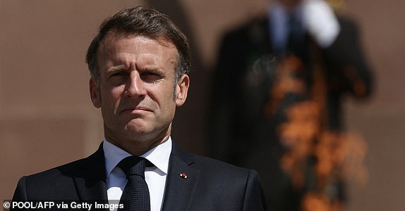 France's President Emmanuel Macron stands to attention near the 'Flamme du souvenir" (flame of memory) as he attends a ceremony marking the 85th anniversary of late French General Charles de Gaulle's World War II resistance call of June 18, 1940, at the Mont-Valerien memorial in Suresnes, outside Paris, on June 18, 2025. (Photo by Alain JOCARD / POOL / AFP) (Photo by ALAIN JOCARD/POOL/AFP via Getty Images)