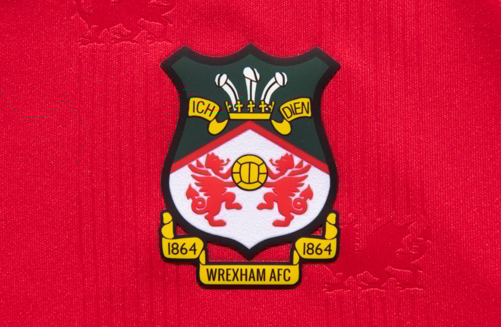 The official club badge of Wrexham AFC on a home shirt
