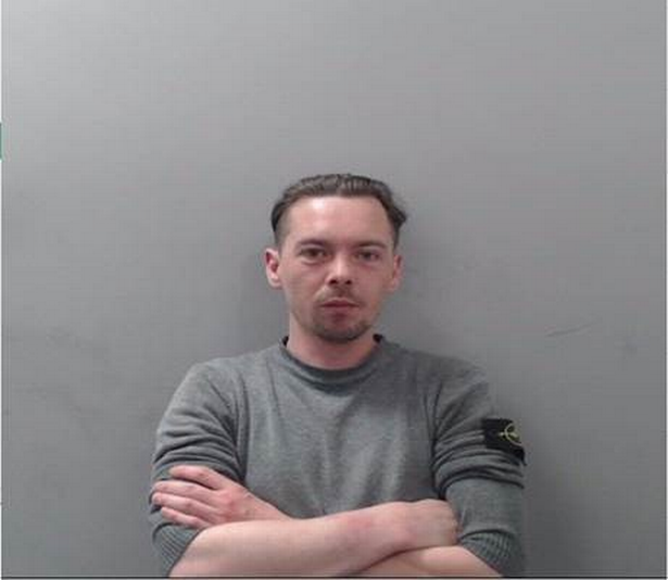 Aaron Thomas Curragh PSNI mugshot in grey top with dark hair 