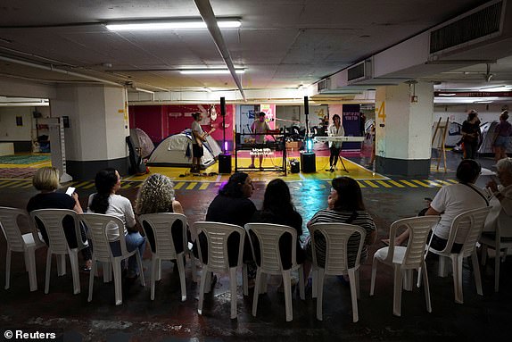 Residents gather to listen to live music in an underground parking lot turned into a shelter, amid the Iran-Israel conflict, in Tel Aviv, Israel, June 21, 2025. REUTERS/Violeta Santos Moura