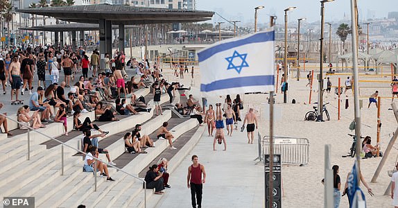epaselect epa12191429 People enjoy the beach in Tel Aviv, Israel, 22 June 2025, amid Iranian ballistic missile attack threats across the country. Israel has been conducting a campaign across Iran since 13 June, targeting nuclear, military, and energy facilities, prompting Iran to launch retaliatory waves of missiles and drones toward Israel.  EPA/ABIR SULTAN