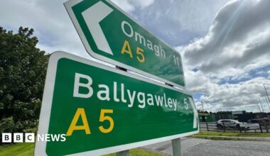 Two green road signs with white writing. One is pointed towards Omagh, the other to Ballygawley