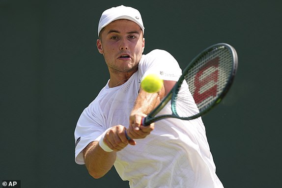 Arthur Fery of Britain returns the ball to Alexei Popyrin of Australia during their first round men's single match at the Wimbledon Tennis Championships in London, Monday, June 30, 2025. (AP Photo/Kirsty Wigglesworth)