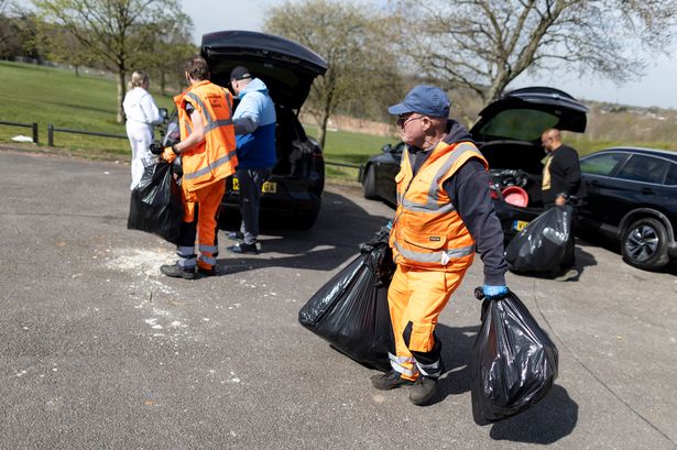  Residents hand rubbish to refuse workers at a Mobile Household Waste Centre in Senneleys Park on April 08, 2025