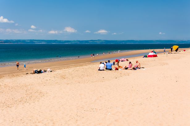 Tourists on the large sandy beach in Priory Bay on Caldey Island off the coast of Tenby, Wales