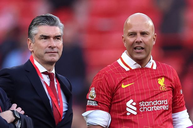 Arne Slot, head coach of Liverpool, speaks to sporting director Richard Hughes after the team's victory and confirmation of winning the Premier League title in the Premier League match between Liverpool FC and Tottenham Hotspur FC at Anfield