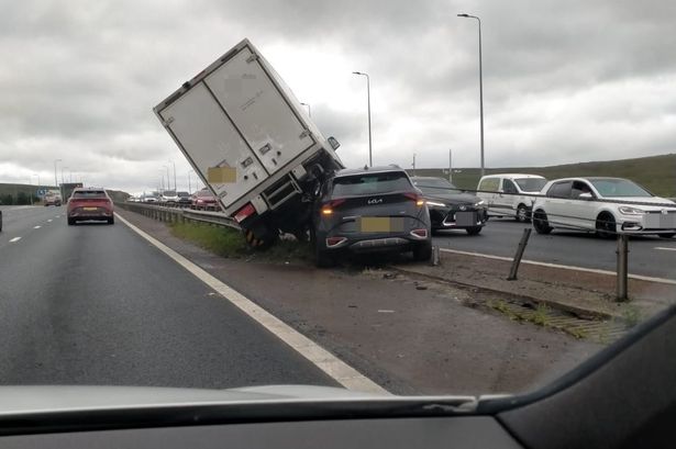 Horrifying images captured the moment a lorry smashed into the central reservation with another car wedged underneath