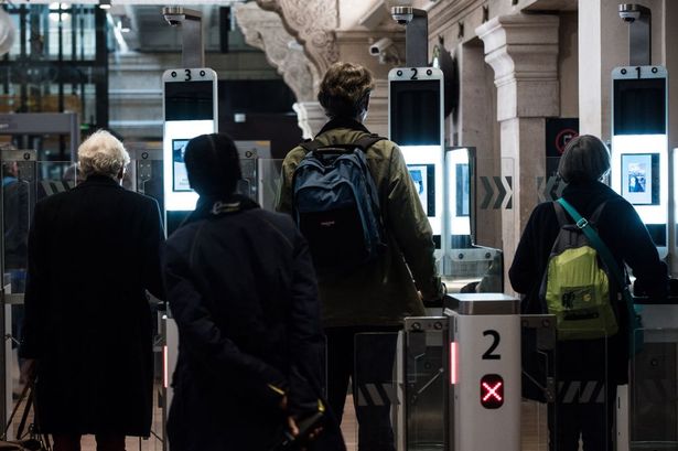 Passengers use their biometric passport at an automated ePassport gate equiped with a facial recognition system 