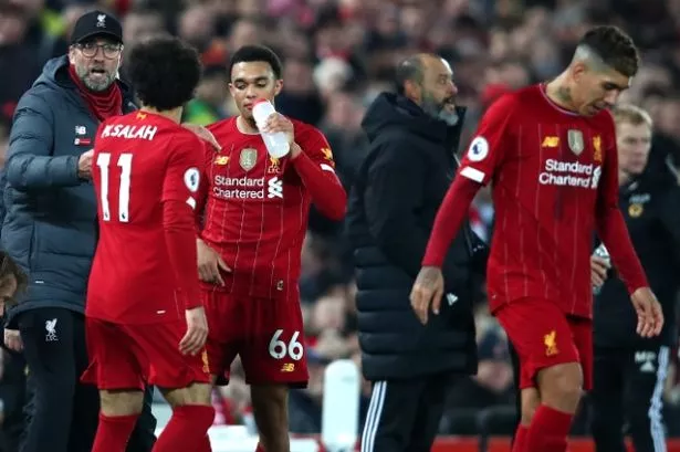 LIVERPOOL, ENGLAND - DECEMBER 29: Jurgen Klopp, Manager of Liverpool speaks with Mohamed Salah and Trent Alexander-Arnold of Liverpool  during the Premier League match between Liverpool FC and Wolverhampton Wanderers at Anfield on December 29, 2019 in Liverpool, United Kingdom. (Photo by Clive Brunskill/Getty Images)