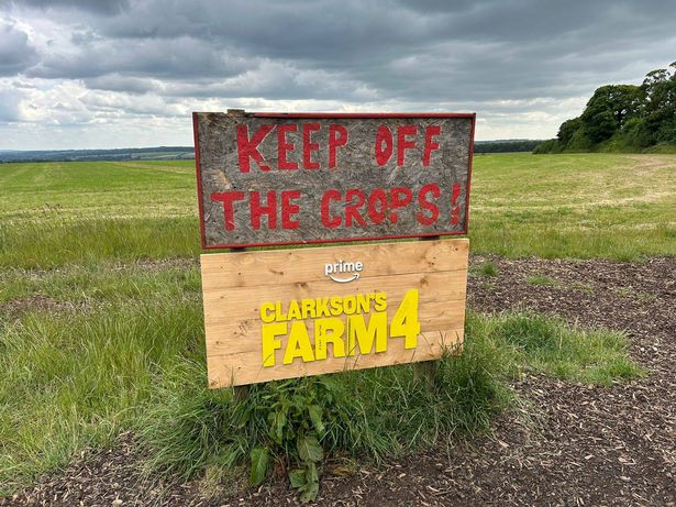 A sign tells visitors to keep off the grass and advertises series four of Clarkson's Farm